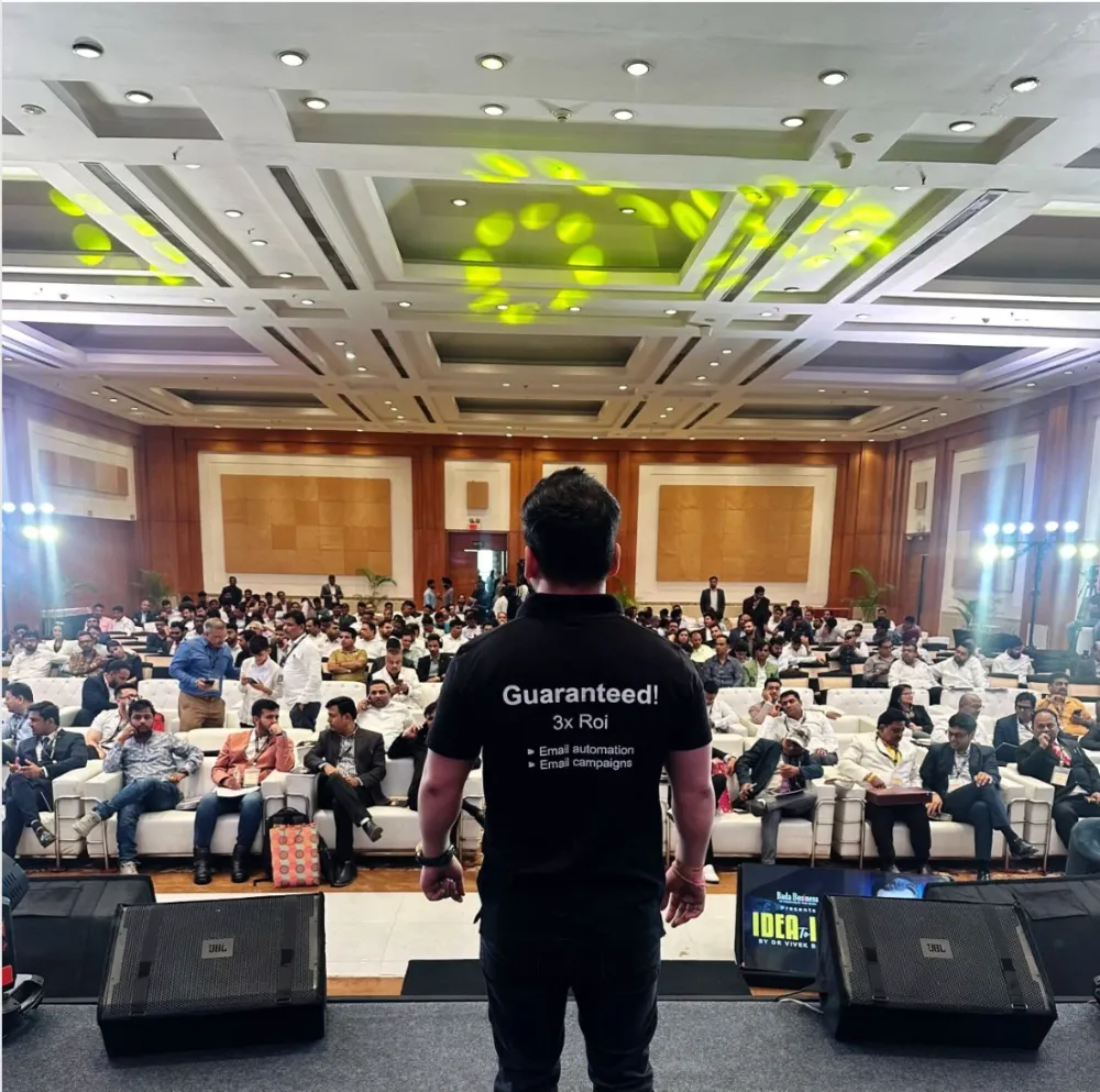 Ravinderpal Singh on stage, speaking to a full conference hall about email marketing